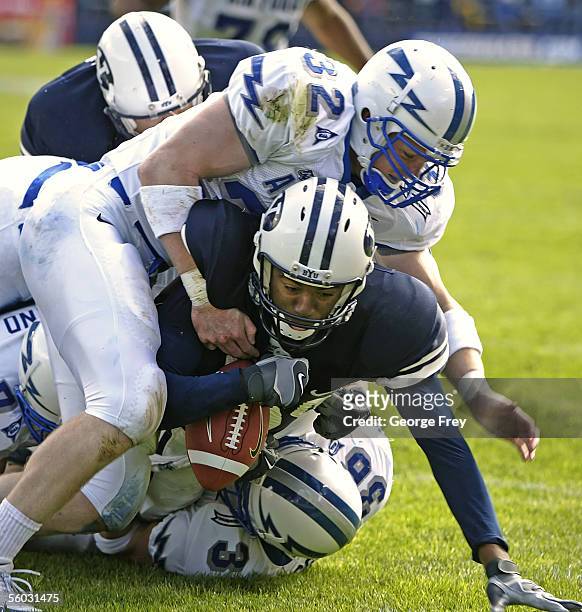 John Rabold and Brad Meissen of Air Force tackle Michael Reed of Brigham Young University during the second quarter October 29, 2005 at LaVell...
