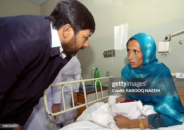 Pakistan cricket captain Inzamam-ul Haq talks with the mother of an injured earthquake survivor at the Pakistan Institute of Medical Science hospital...