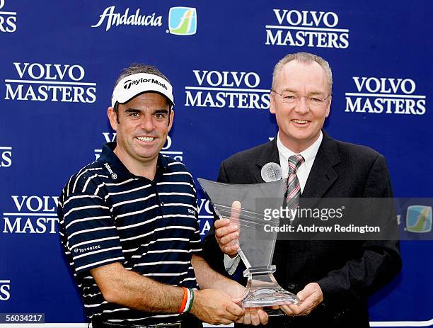 Paul McGinley of Ireland receives the trophy from Mel Pyatt of Volvo Event Management after winning the Volvo Masters at the Valderrama Golf Club on...
