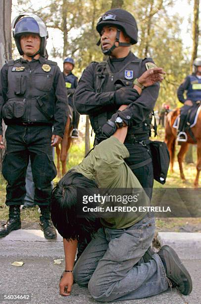 Un policia detiene a un aficionado de los Pumas de la Universidad Nacional, los cuales causaron destrozos luego que su equipo perdiera contra...