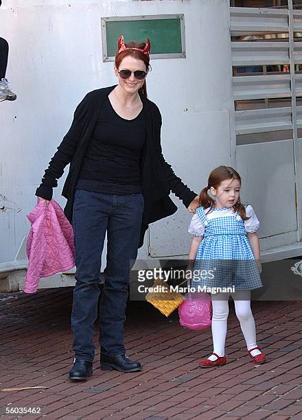 Actress Julianne Moore, with devil horns, stands with her daughter, Liv Helen, dressed as Dorothy from "The Wizard of Oz", at a Halloween party in a...