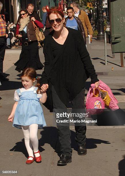 Actress Julianne Moore, with devil horns, walks with her daughter, Liv Helen, dressed as Dorothy from "The Wizard of Oz", at a Halloween party in a...