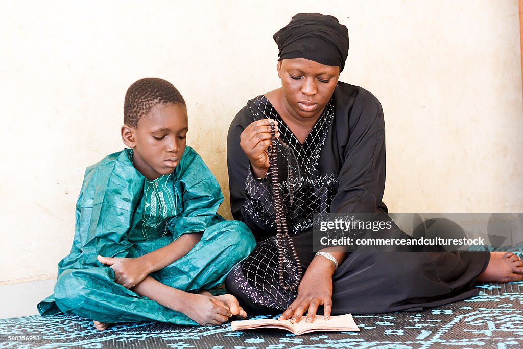 Mother and son reading a prayers' book