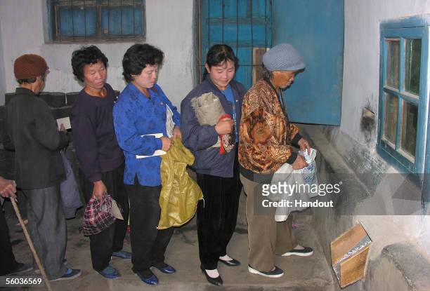 North Korean women queue to receive corn at a public distribution centre on October 17, 2005 in Sohung County, north Hwanghae province, North Korea....