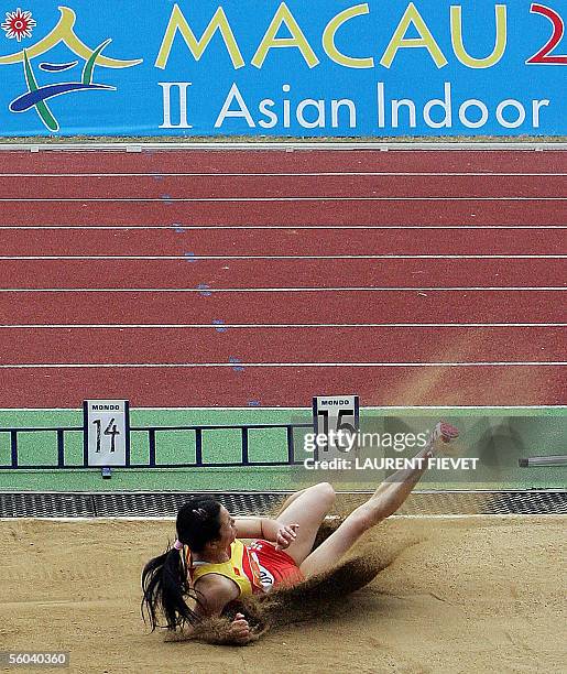 Chinese Huang Qiu-yan lands in the sand to claim first place in the women's triple jump during the 4th East Asian Games in Macau, 01 November 2005....