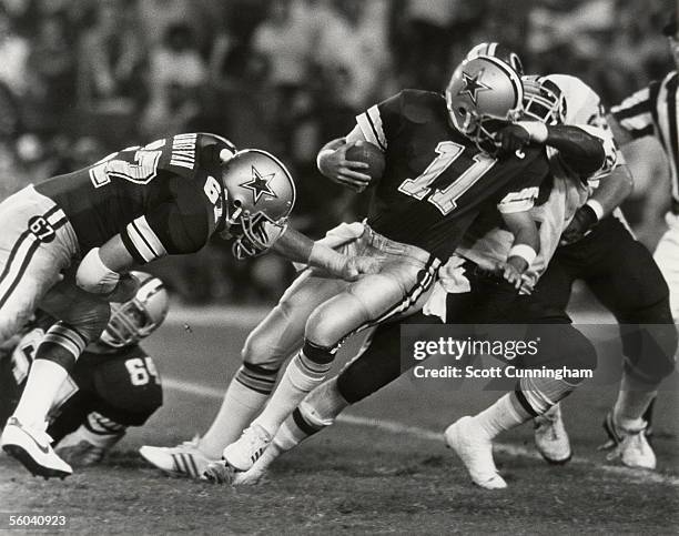 Quarterback Danny White of the Dallas Cowboys is taken down by the facemask by Dexter Manley of the Washington Redskins at RFK Stadium in Washington,...