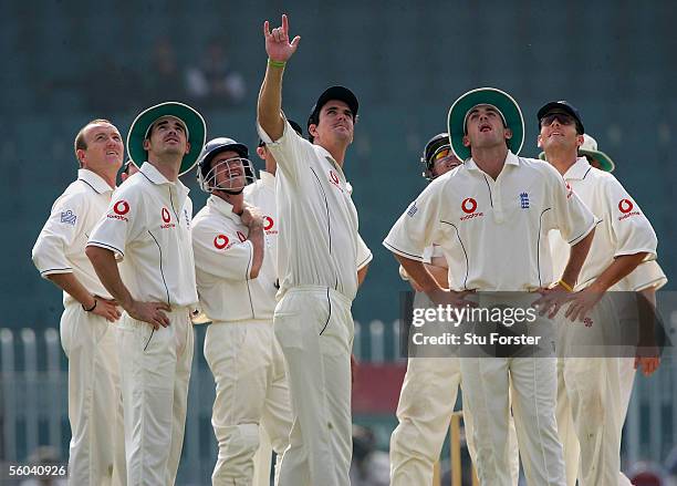 Kevin Pietersen and the England fielders points skywards as a RAF Chinook rescue helicopter flys over head during the second day of the three day...