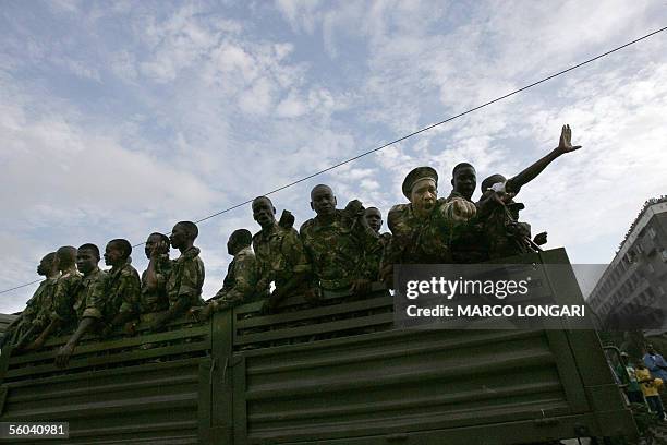 Member of the Tanzanian armed forces react towards a photographer as others aboard of an army truck celebrate the victory of the rulling...