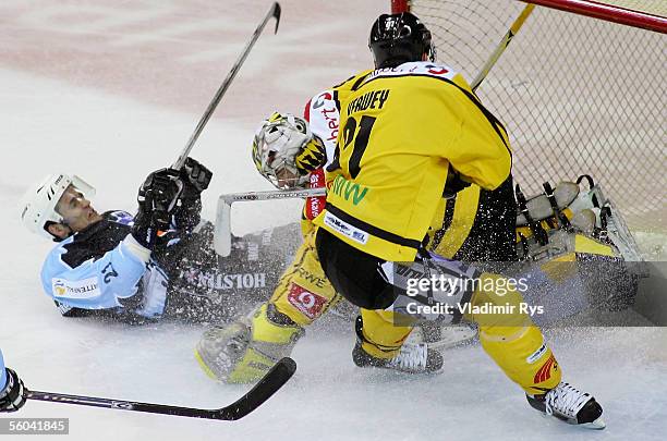 Darren Van Impe of Hamburg clashes with goalkeeper Robert Muller of Krefeld as his team mate Roland Verwey tries to stop the puck before the goal...