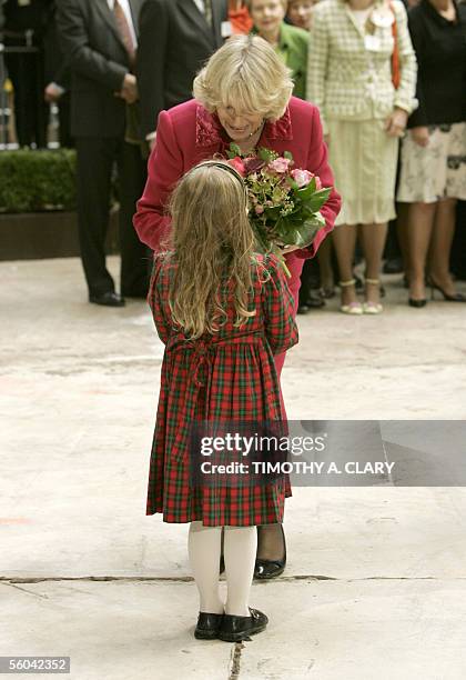 New York, UNITED STATES: Camilla, Duchess of Cornwall, the wife of Britain's Prince Charles, gets flowers from five-year-old Katherine Beaumont after...