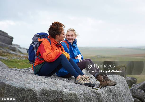 hikers sitting on large rock in moorland - orange shoe stock-fotos und bilder