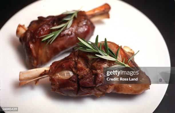 Lamb shanks with rosemary garnish.