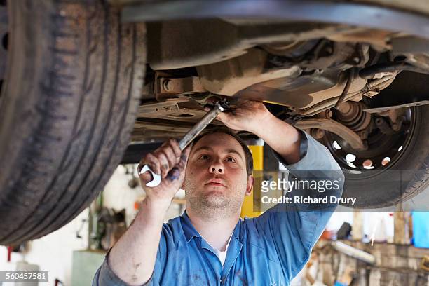 garage mechanic tightening sump bung - car suspension stock pictures, royalty-free photos & images