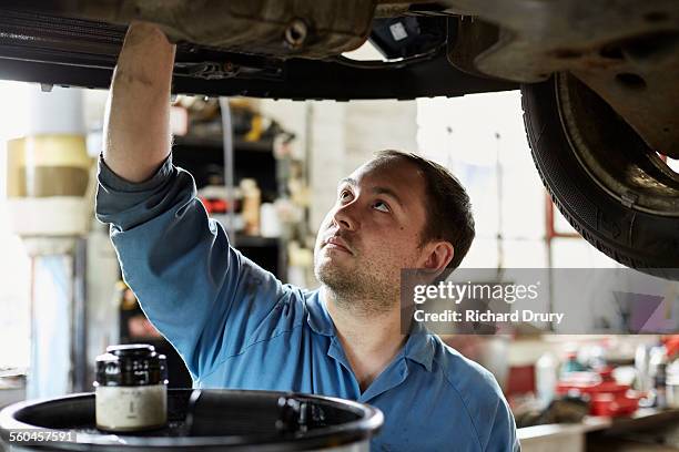 car mechanic changing engine oil - car suspension stock pictures, royalty-free photos & images