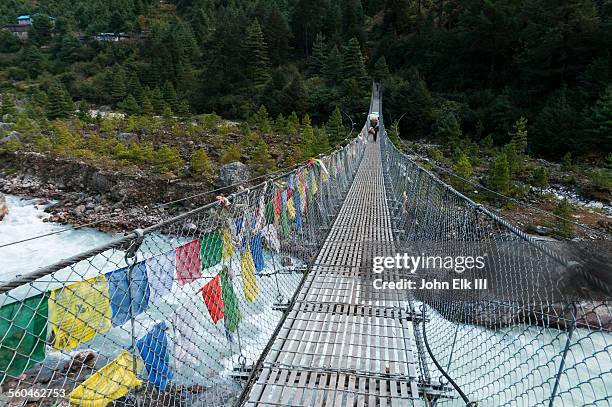 porter crossing dudh kosi gorge suspension bridge - dudh kosi river stock pictures, royalty-free photos & images