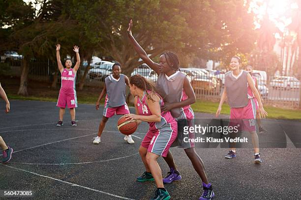 Female basket players dribbling and tackling