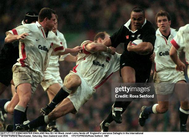 All Black Jonah Lomu fends off England's Lawrence Dallaglio in the international at Old Trafford, Manchester, Saturday. New Zealand won 258.