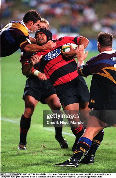 Chief's Mark Robinson makes a head high tackle on Norman Berryman of the Crusaders during the Super 12 clash at North Harbour Stadium, Saturday.