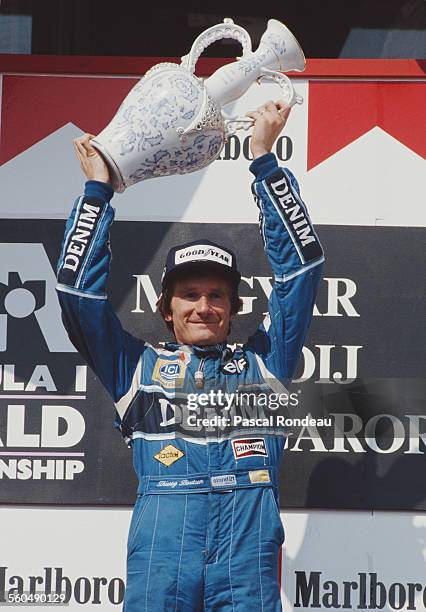 Thierry Boutsen of Belgium, driver of the Canon Williams Renault Williams FW13B Renault V10 celebrates with the trophy after winning the Hungarian...