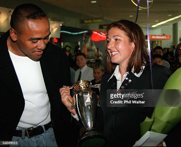 Gal Black Tracey Waters gives Jonah Lomu a look at the trophy as the team arrives home at Auckland Airport following their win over USA in the final...