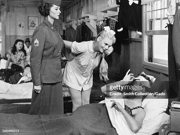 Rosalind Russell and Marie Wilson in an army barracks, in a scene from the film 'Never Wave at a WAC,' 1953.