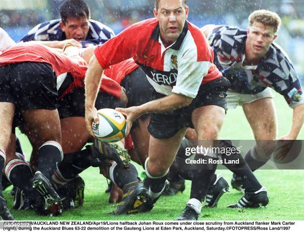 Lions halfback Johan Roux comes under close scrutiny from Auckland flanker Mark Carter r, during the Auckland Blues 6322 demolition of the Gauteng...