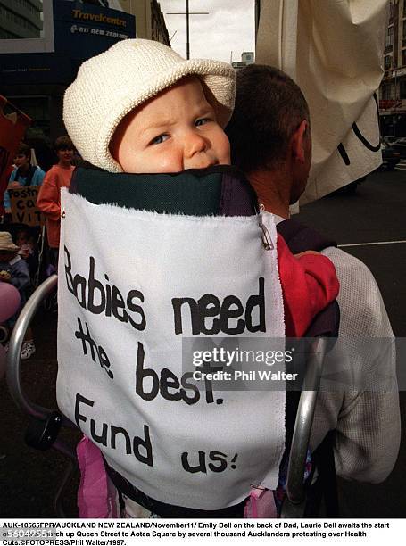 Emily Bell on the back of Dad, Laurie Bell awaits the start of a protest march up Queen Street to Aotea Square by several thousand Aucklanders...