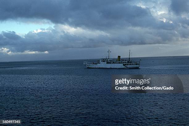 Fishing boat in tropical sea with low cloud cover, at twilight, the Fiji Islands, Republic of Fiji, 1976.