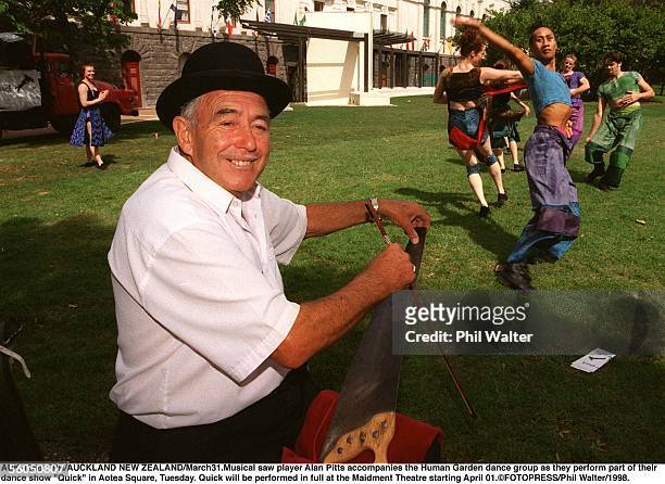 Musical saw player Alan Pitts accompanies the Human Garden dance group as they perform part of their rdance show "Quick" in Aotea Square, Tuesday....