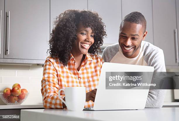 man and woman looking at laptop computer. - woman look straight black shirt stock pictures, royalty-free photos & images