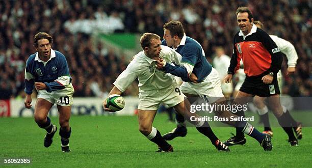 England's Matt Dawson slips the ball in the tackle of Italy's Paulo Vaccari in the Rugby World Cup match at Twickenham, London, Saturday. England won...