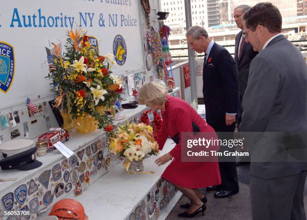 Camilla, Duchess of Cornwall, places flowers as Prince Charles, Prince of Wales, and orthers look on as they visit the area known as Ground Zero, the...