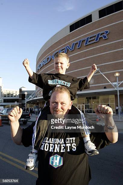 Kai Harwood and his son Darren Harwood, 4-years-old, from Norman, Oklahoma, cheer on the New Orleans/Oklahoma City Hornets before the opening game...