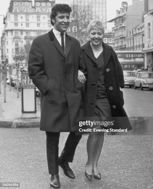 Welsh singer Tom Jones and his wife Linda walking down a street, 1965.