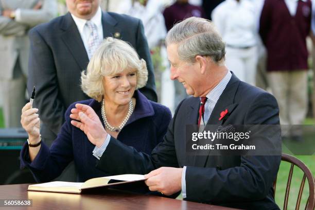 Prince Charles, Prince of Wales and Camilla, Duchess of Cornwall giggle as she is reluctant to return his pen as they sign the visitors' book at SEED...