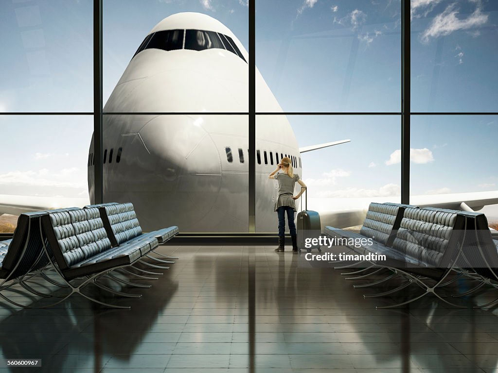 Girl making call in a sunny airport terminal