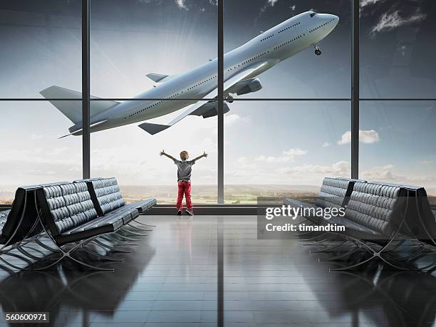 boy looking at airplane taking off in airport term - airline seat stock pictures, royalty-free photos & images