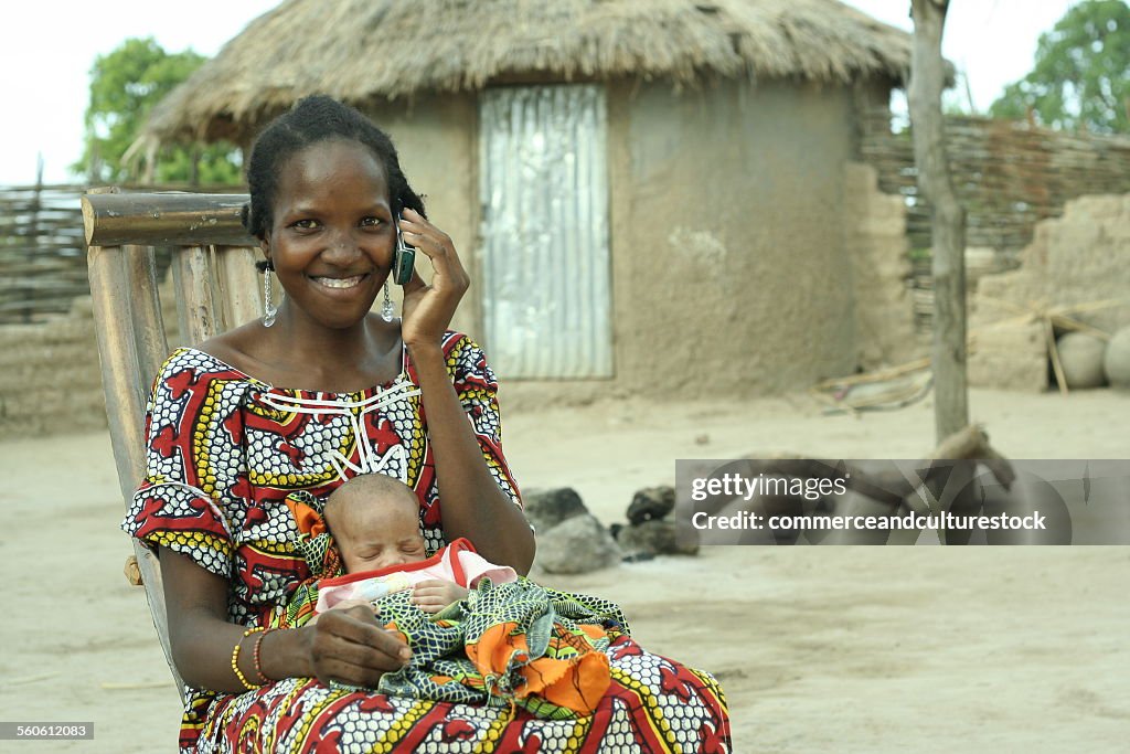 A village woman with a baby having a call