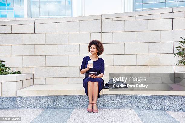 businesswoman thinking as she sits outside - modern maturity center foto e immagini stock