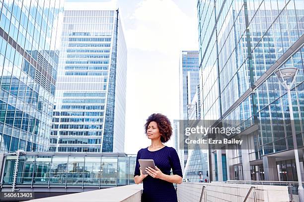 senior executive on tablet in business district - modern maturity center stock pictures, royalty-free photos & images