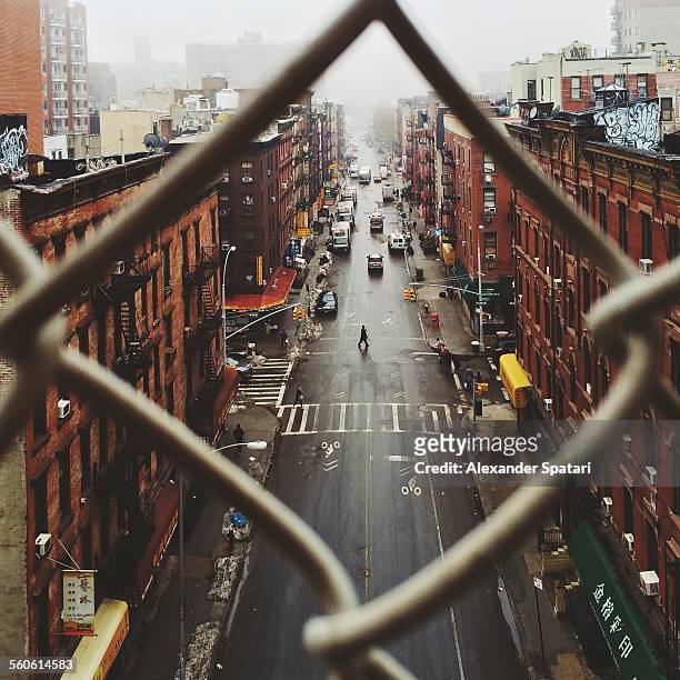 chinatown seen through fence on a foggy day, nyc - lower east side manhattan stock pictures, royalty-free photos & images
