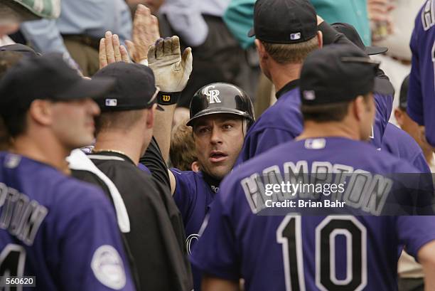 Todd Zeile of the Colorado Rockies gets high fives after hitting a two-run home run against the Houston Astros in the eighth inning at Coors Field in...