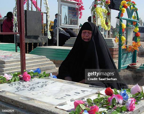 An Iraqi woman cries as she visits her relative's grave at the Najaf cemetery in the first day of Eid al-Fitr holiday on November 3, 2005 in the holy...