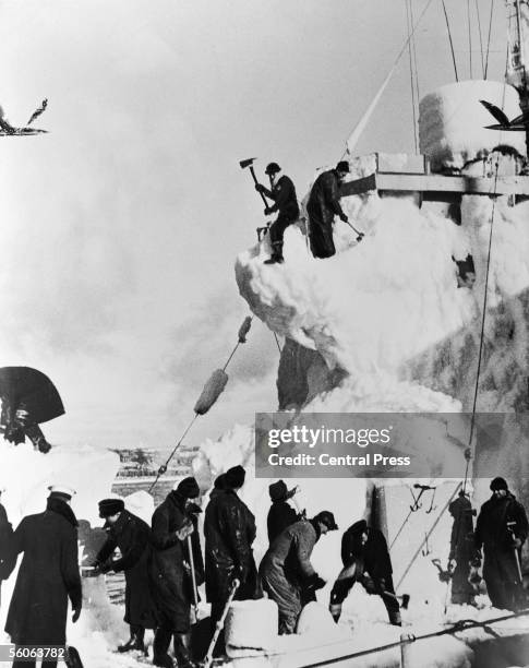 The crew of a British destroyer clear the snow and ice from her decks, whilst on convoy escort duty in the North Atlantic, 11th April 1943.