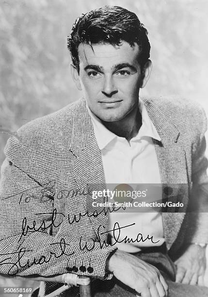 Stuart Whitman signed headshot, sitting on a director's chair and staring at the camera, 1954.