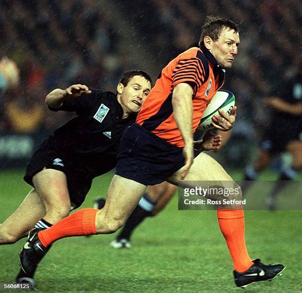 Scotland halfback Gary Armstrong about to be tackled by New Zealand's Andrew Mehrtens in the quarter final of the Rugby World Cup at Murrayfield,...