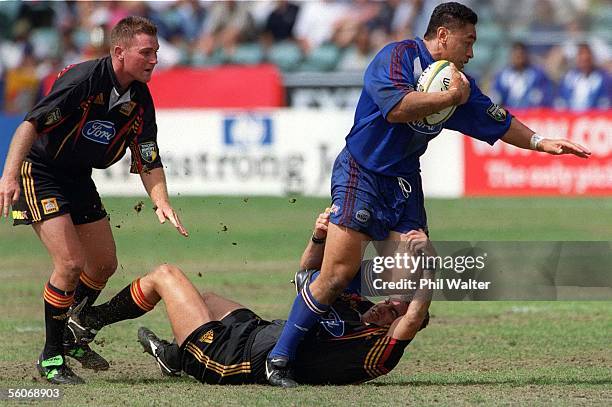 Auckland Blues Eroni Clarke is tackled by Waikato Chiefs Glen Marsh as Glen Jackson looks on during their Super 12 match played at the North Harbour...