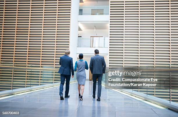 business people walking on office balcony - on the move rear view stockfoto's en -beelden