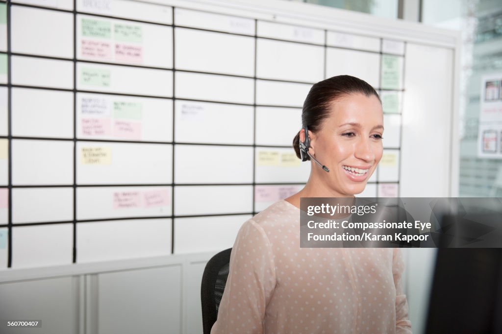 Businesswoman wearing headset in office