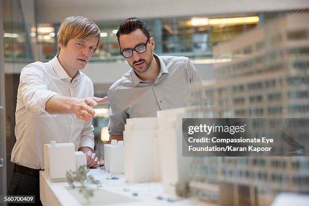 business people looking at model building - architectural model stockfoto's en -beelden